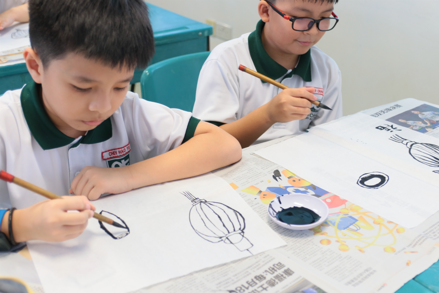 Students carefully painting traditional lantern designs with brushes and ink